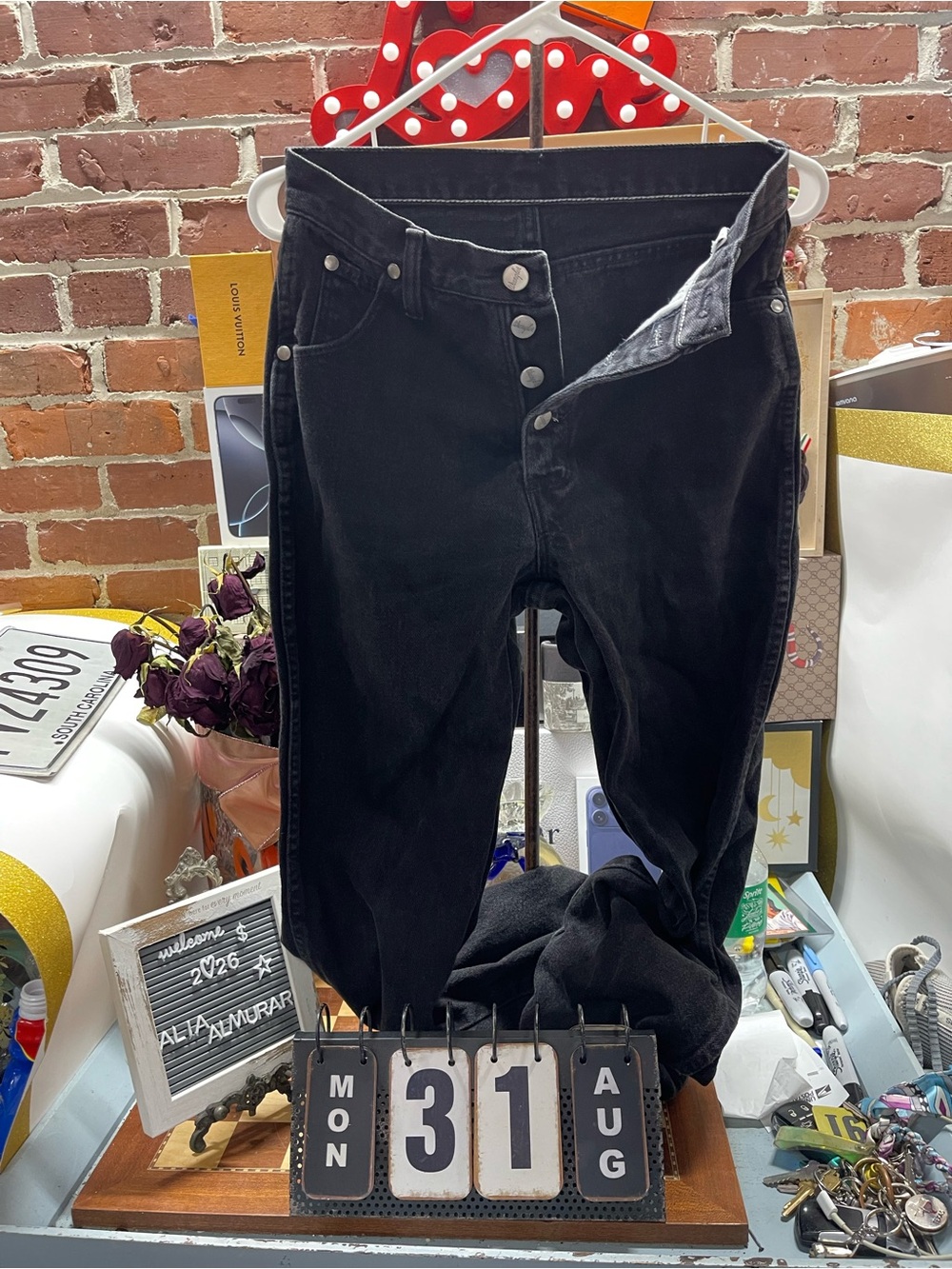 Vtg black Wrangler denim jeans featuring branded silver-tone metal buttons.